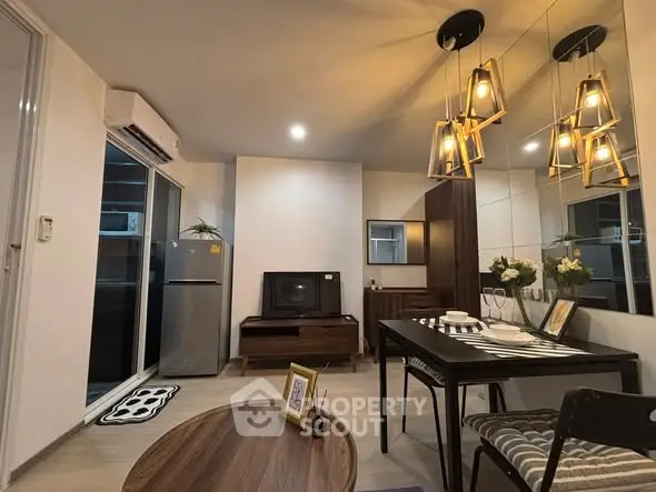 Modern living room with stylish lighting and elegant decor, featuring a dining area and sleek furniture.