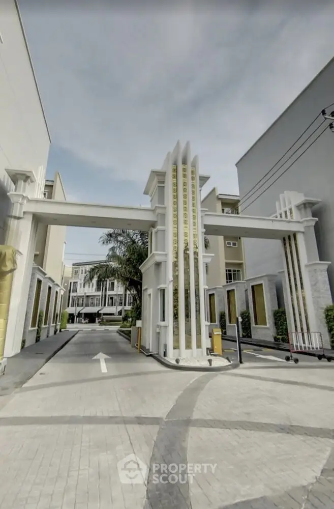 Elegant gated entrance of modern residential complex with art deco design elements.