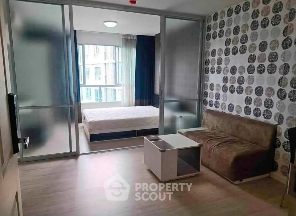 Modern studio apartment with stylish decor and sliding glass doors separating bedroom and living area.