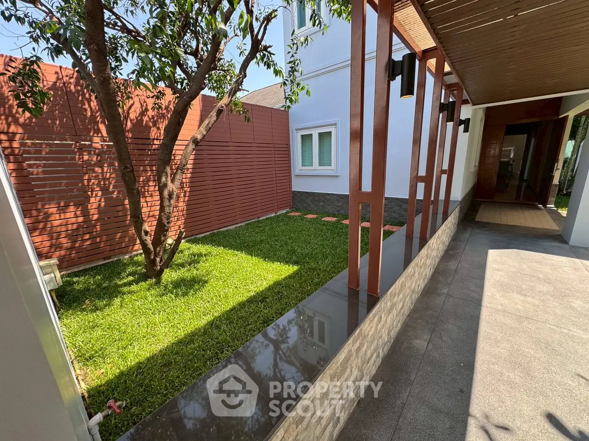 Charming garden area with lush greenery and modern design elements in a residential property.