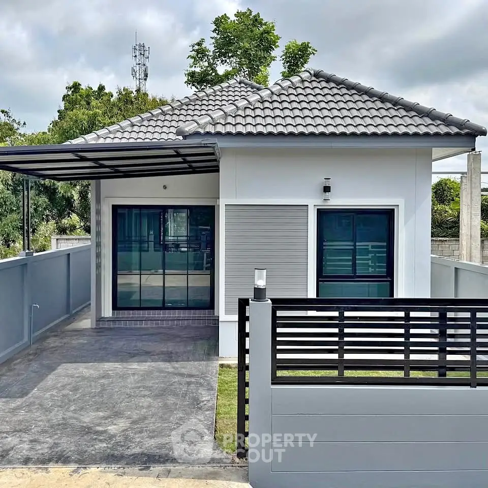 Modern single-story house with tiled roof and gated driveway