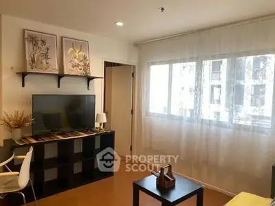 Cozy living room with modern decor and large window, perfect for relaxation.