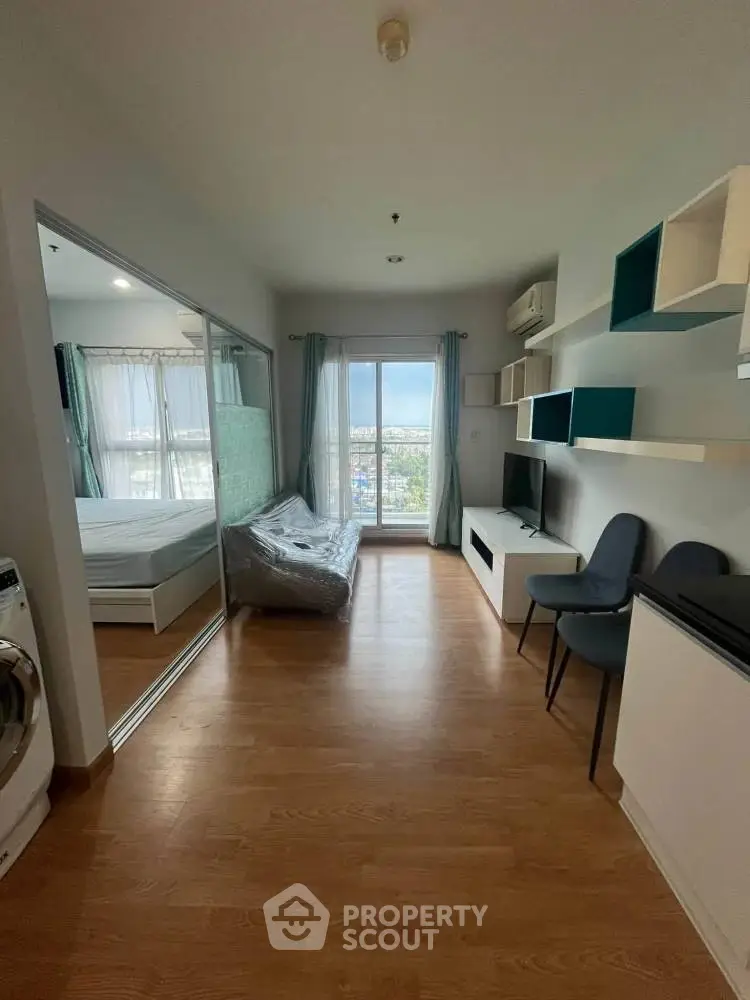 Modern apartment interior with wooden flooring, large window, and stylish furniture.