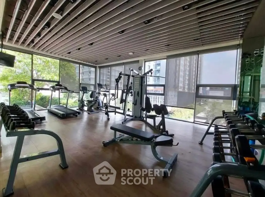 Spacious modern gym with state-of-the-art equipment and large windows offering a scenic view.