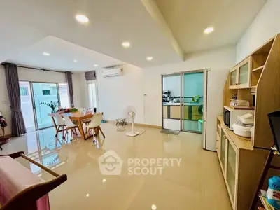 Spacious modern living room with dining area and sliding glass doors, perfect for family gatherings.