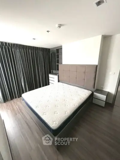 Spacious bedroom with modern design and large windows for natural light.
