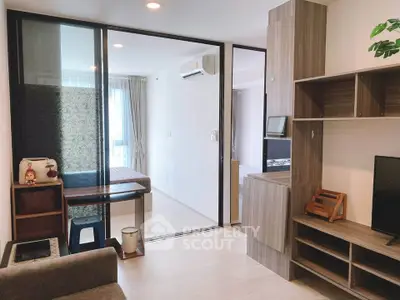 Modern apartment interior with open living room and bedroom, featuring stylish furniture and natural light.