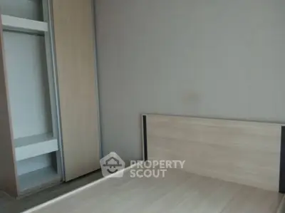 Minimalist bedroom with wooden flooring and built-in wardrobe