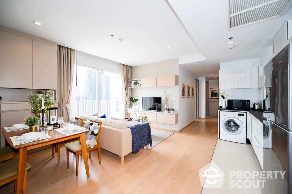 Modern open-plan living room with kitchen and dining area in a bright apartment