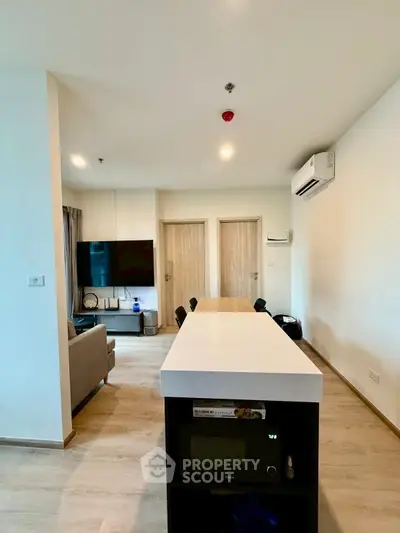 Modern living room with sleek design and open layout, featuring a stylish TV setup and air conditioning.