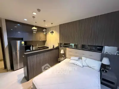 Modern studio apartment with sleek kitchen and cozy bedroom area, perfect for urban living.