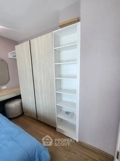 Modern bedroom with wooden flooring, built-in wardrobe, and shelving unit for stylish storage solutions.