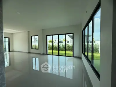 Spacious modern living room with large windows and garden view