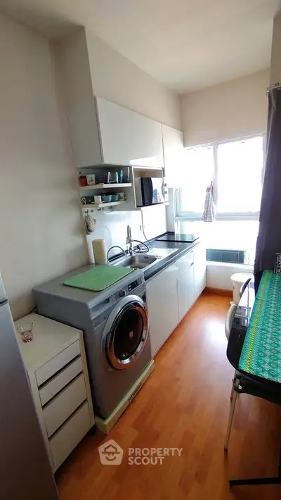 Modern kitchen with washing machine and ample natural light