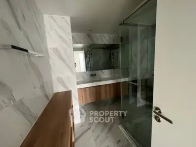 Modern bathroom with marble tiles and glass shower enclosure