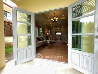 Charming living room with elegant decor and garden view through French doors.