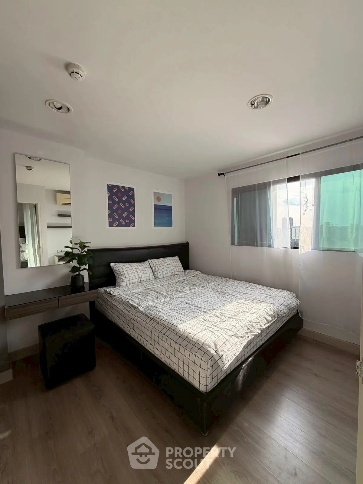 Cozy bedroom with modern decor and ample natural light.
