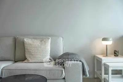 Modern living room with cozy sofa and stylish lamp on side table.