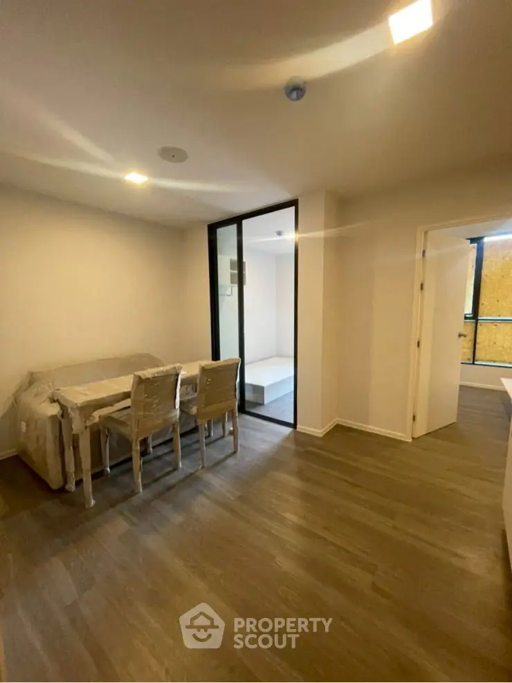 Spacious modern living room with elegant flooring and ample natural light.