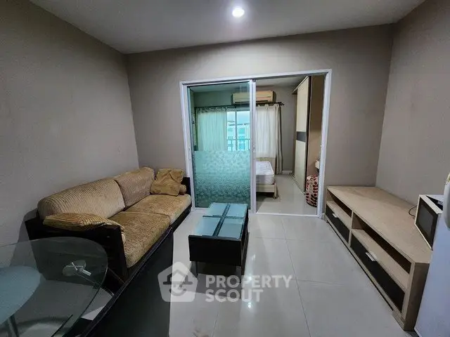 Cozy living room with modern furniture and sliding glass door to bedroom