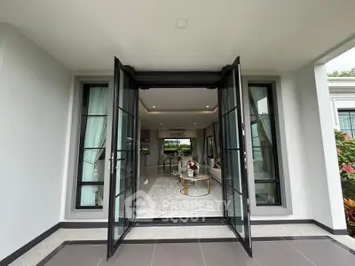 Luxurious open living room with elegant decor and large glass doors leading to a garden view.