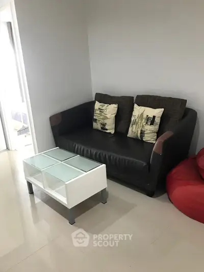 Cozy living room with modern sofa and glass coffee table in stylish apartment.