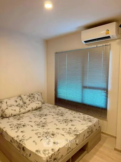 Cozy bedroom with floral bedding and air conditioning, perfect for relaxation.