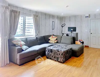 Spacious living room with modern sectional sofa and stylish decor in a bright apartment.