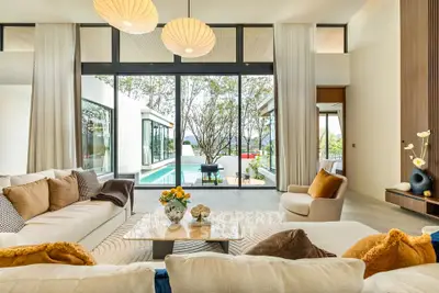 Luxurious living room with pool view, elegant decor, and large windows in modern home.