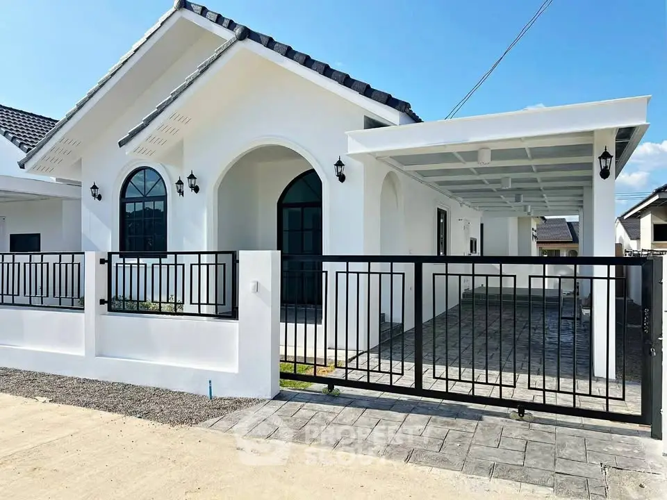 Charming modern white house with gated driveway and stylish arched windows