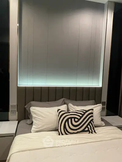 Modern bedroom with stylish headboard and ambient lighting, featuring elegant bedding and decorative pillows.