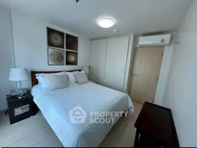 Modern bedroom with stylish decor and ample natural light, featuring a comfortable bed and sleek furnishings.