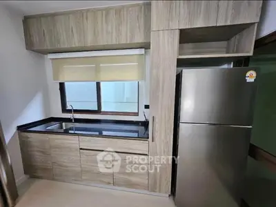 Modern kitchen with sleek cabinetry and stainless steel fridge