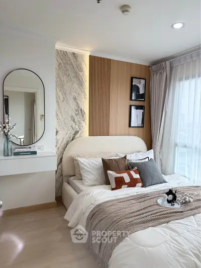 Modern bedroom with stylish decor and large window offering natural light