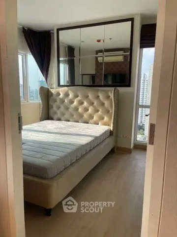 Cozy bedroom with city view and elegant tufted bed in modern apartment