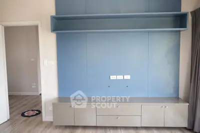 Modern living room with built-in storage and blue accent wall