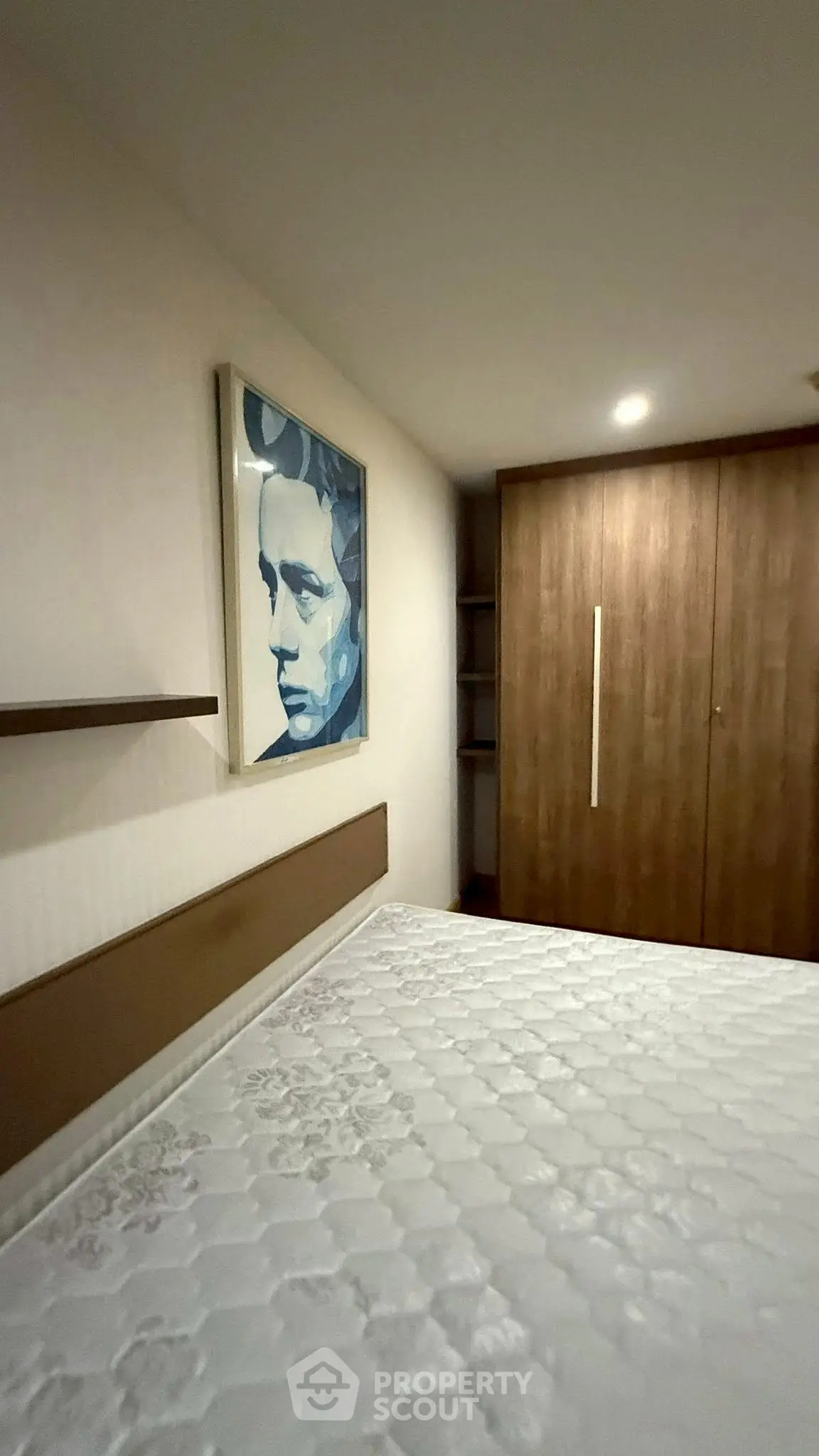 Cozy bedroom with modern art and spacious wardrobe in stylish apartment.