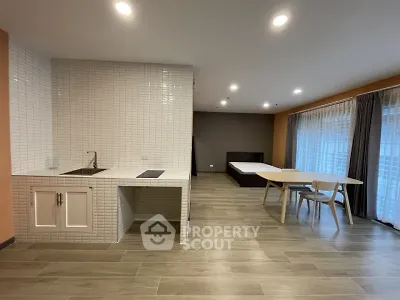 Spacious open-plan living area with modern kitchen and large windows.