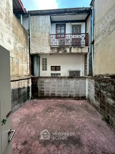 Charming rustic courtyard with potential for renovation in urban setting.
