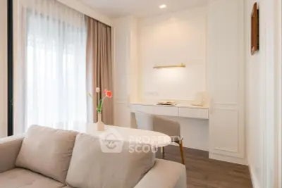 Elegant living room with modern decor and natural light, featuring a cozy sofa and stylish workspace.