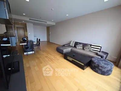 Spacious modern living room with wooden flooring and stylish furniture in a contemporary apartment.