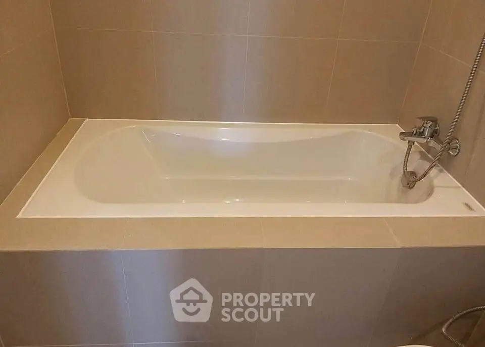 Modern bathroom with sleek bathtub and neutral tile design