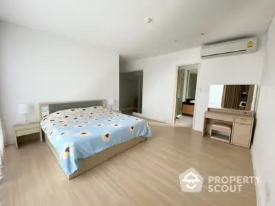 Spacious bedroom with large bed, ample natural light, modern flooring, and sleek furniture, perfect for a restful retreat.