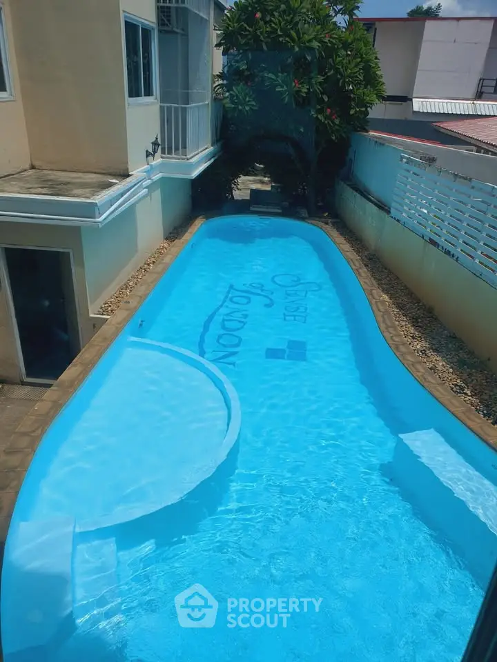 Charming residential pool with serene surroundings and lush greenery, perfect for relaxation and leisure.