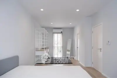 Spacious modern bedroom with minimalist design and ample natural light.