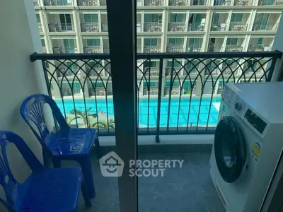 Charming balcony with pool view and washing machine, perfect for relaxation and convenience.