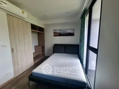 Modern bedroom with large window and built-in wardrobe