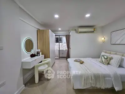 Modern bedroom with elegant decor and city view from balcony.