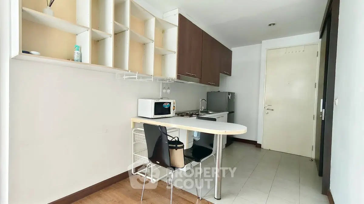 Compact kitchen with modern appliances and open shelving in a cozy apartment
