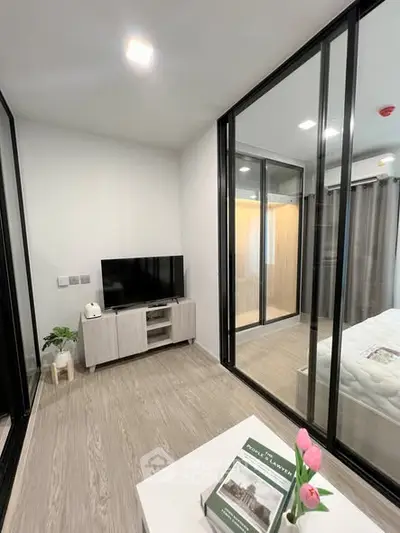 Modern bedroom with glass partitions and sleek decor in a contemporary apartment.